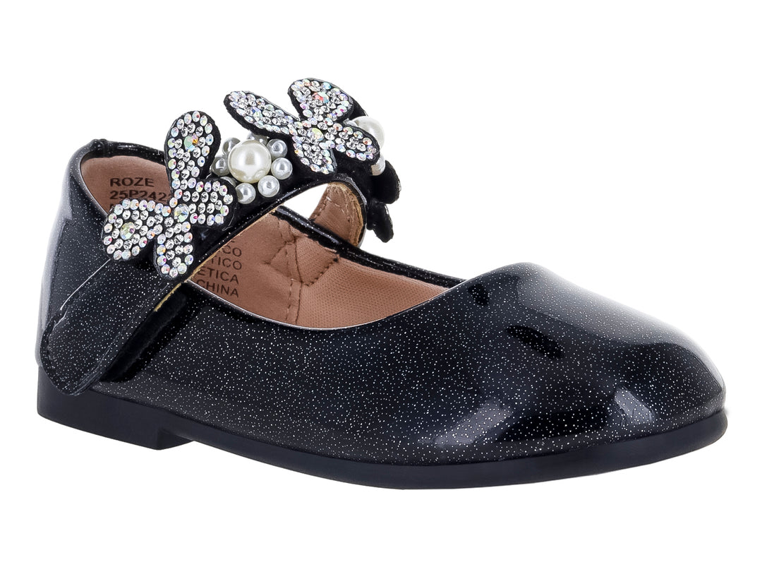Zapato plano negro brillante para niña con moño decorado con pedrería y una perla central.