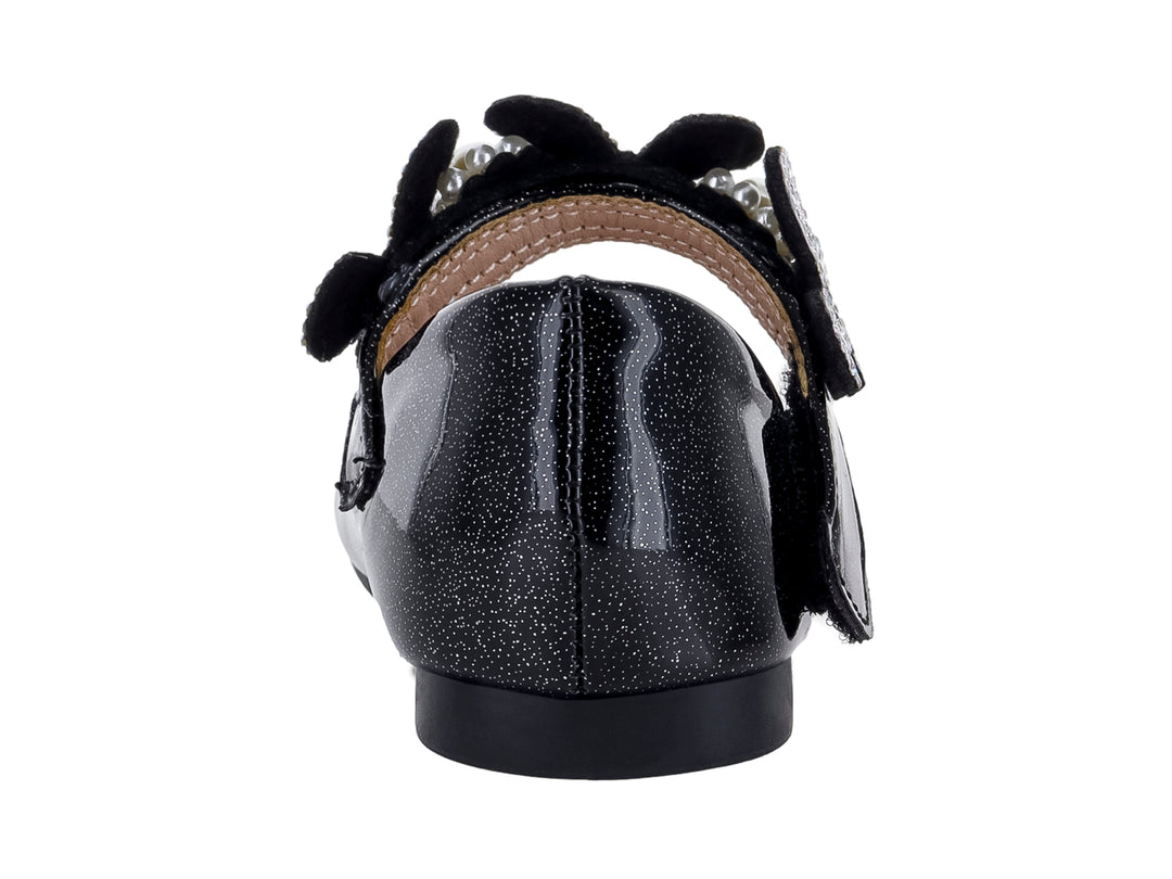 Zapato plano negro brillante para niña con moño decorado con pedrería y una perla central.