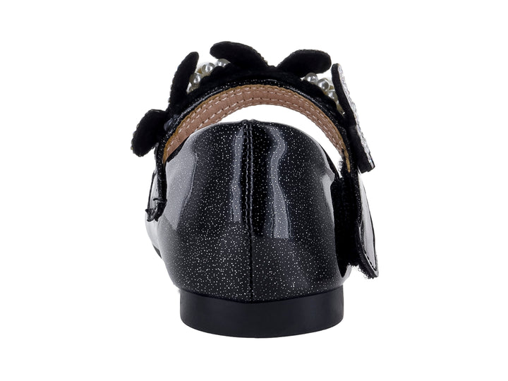 Zapato plano negro brillante para niña con moño decorado con pedrería y una perla central.