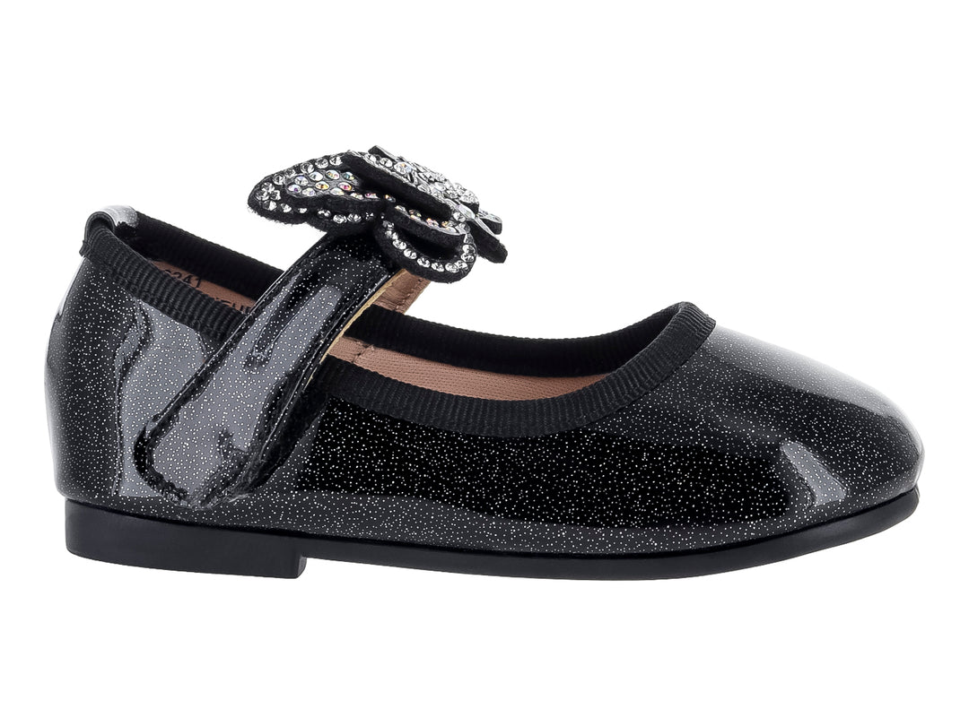 Zapato plano negro brillante para niña con moño decorado con cristales plateados.