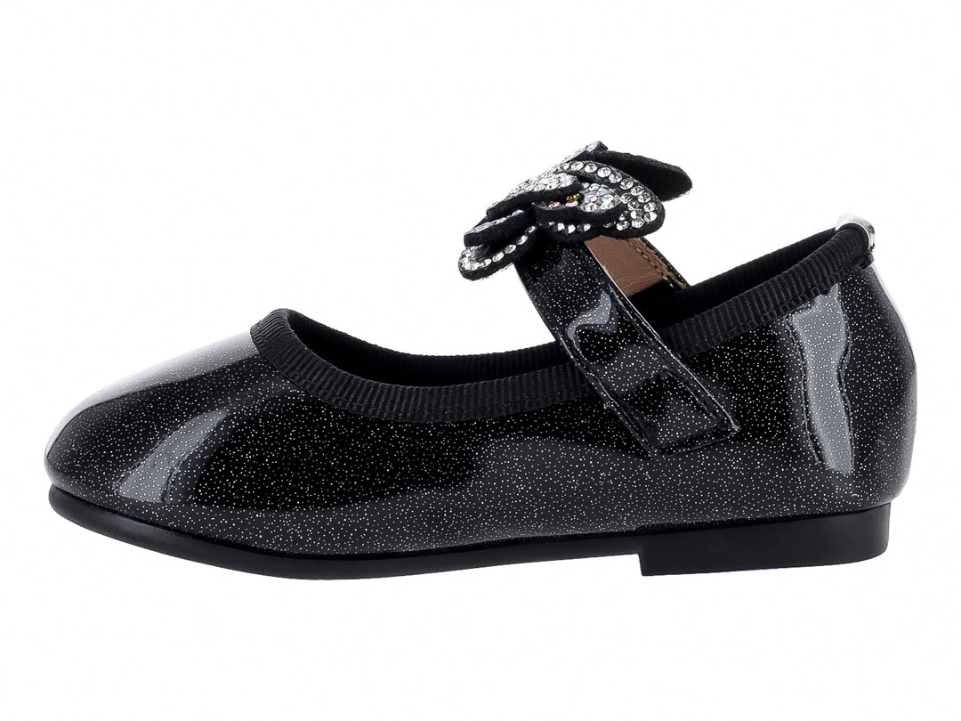Zapato plano negro brillante para niña con moño decorado con cristales plateados.