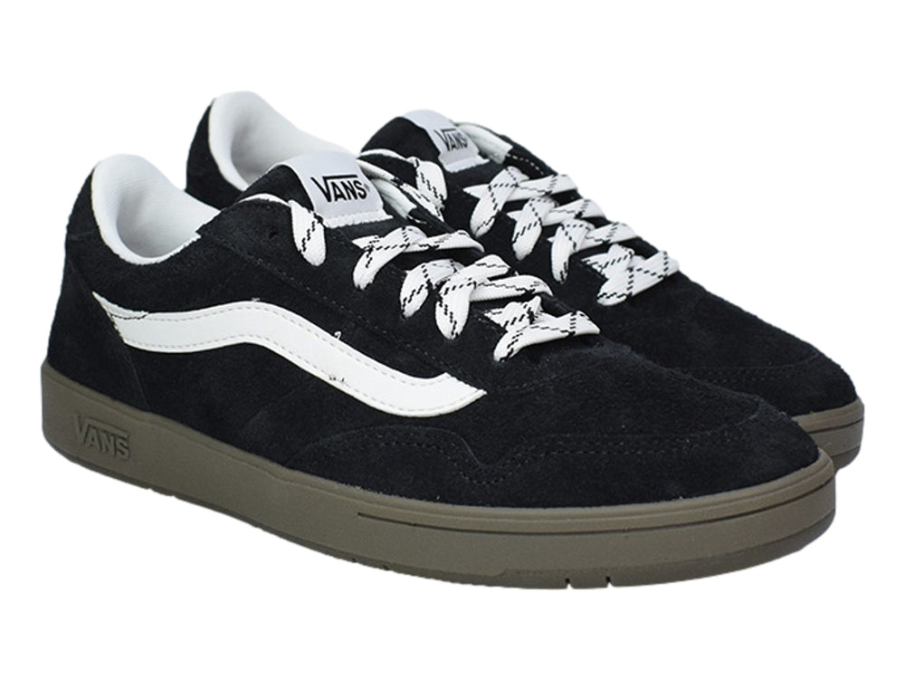 Tenis VANS negros de gamuza con franja lateral blanca y suela color marrón.