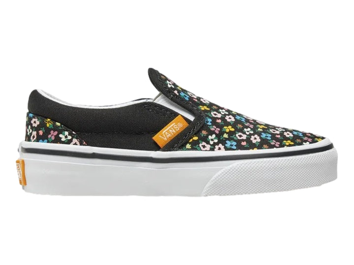 Tenis Vans slip-on negros con estampado de flores multicolores y suela blanca.