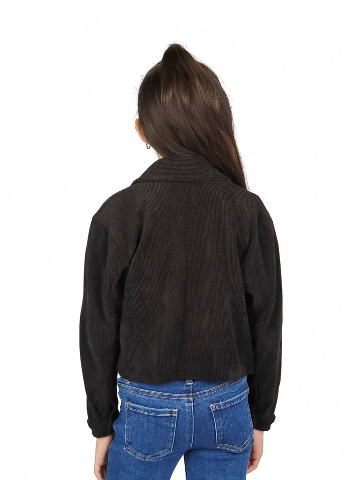 Niña vistiendo una chaqueta corta de color negro con botones y cuello.