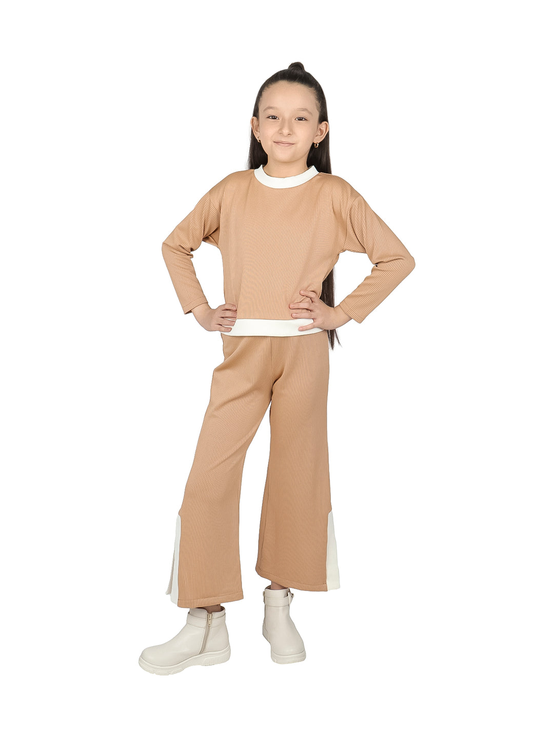 Niña vistiendo conjunto de camiseta y pantalón color camel con detalles en blanco.