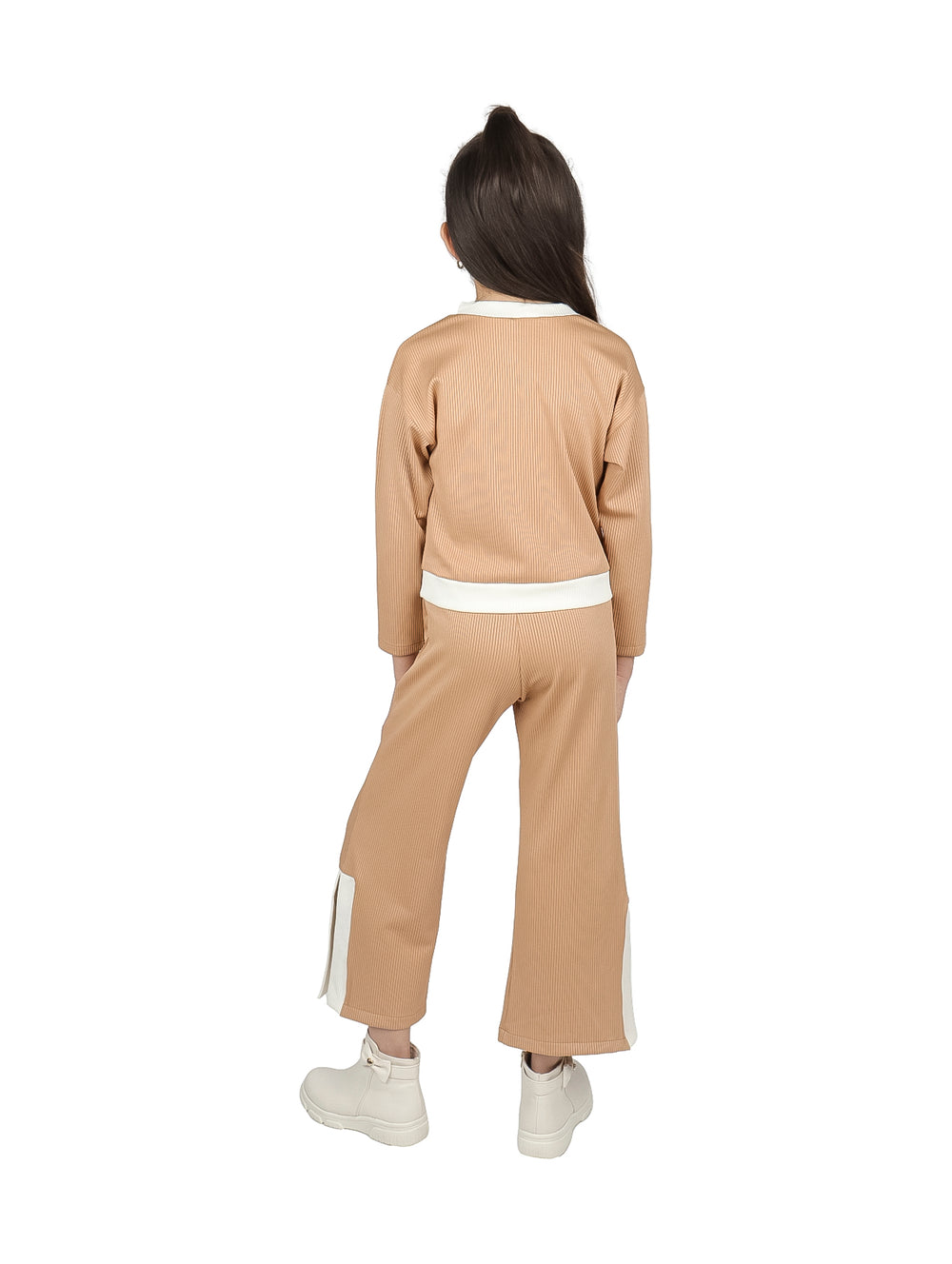 Niña vistiendo conjunto de camiseta y pantalón color camel con detalles en blanco.