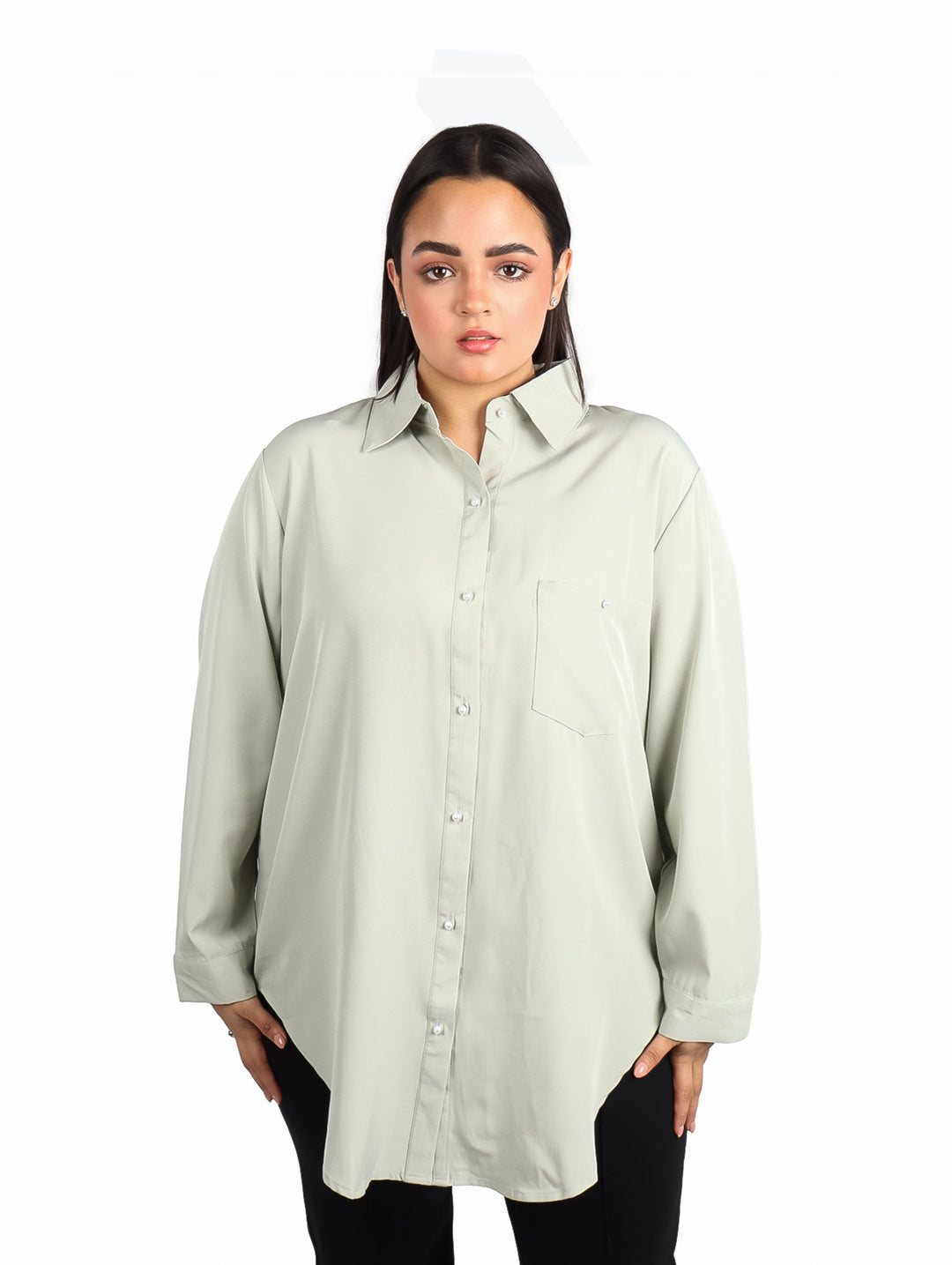 Mujer vistiendo camisa de color verde sage con manga larga y corte holgado.