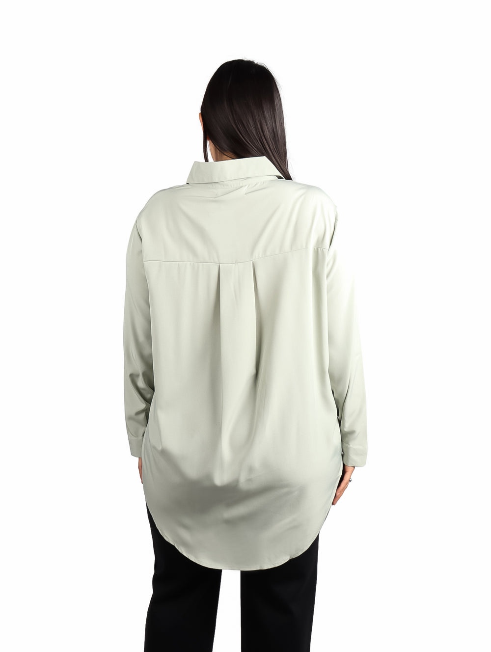 Mujer vistiendo camisa de color verde sage con manga larga y corte holgado.