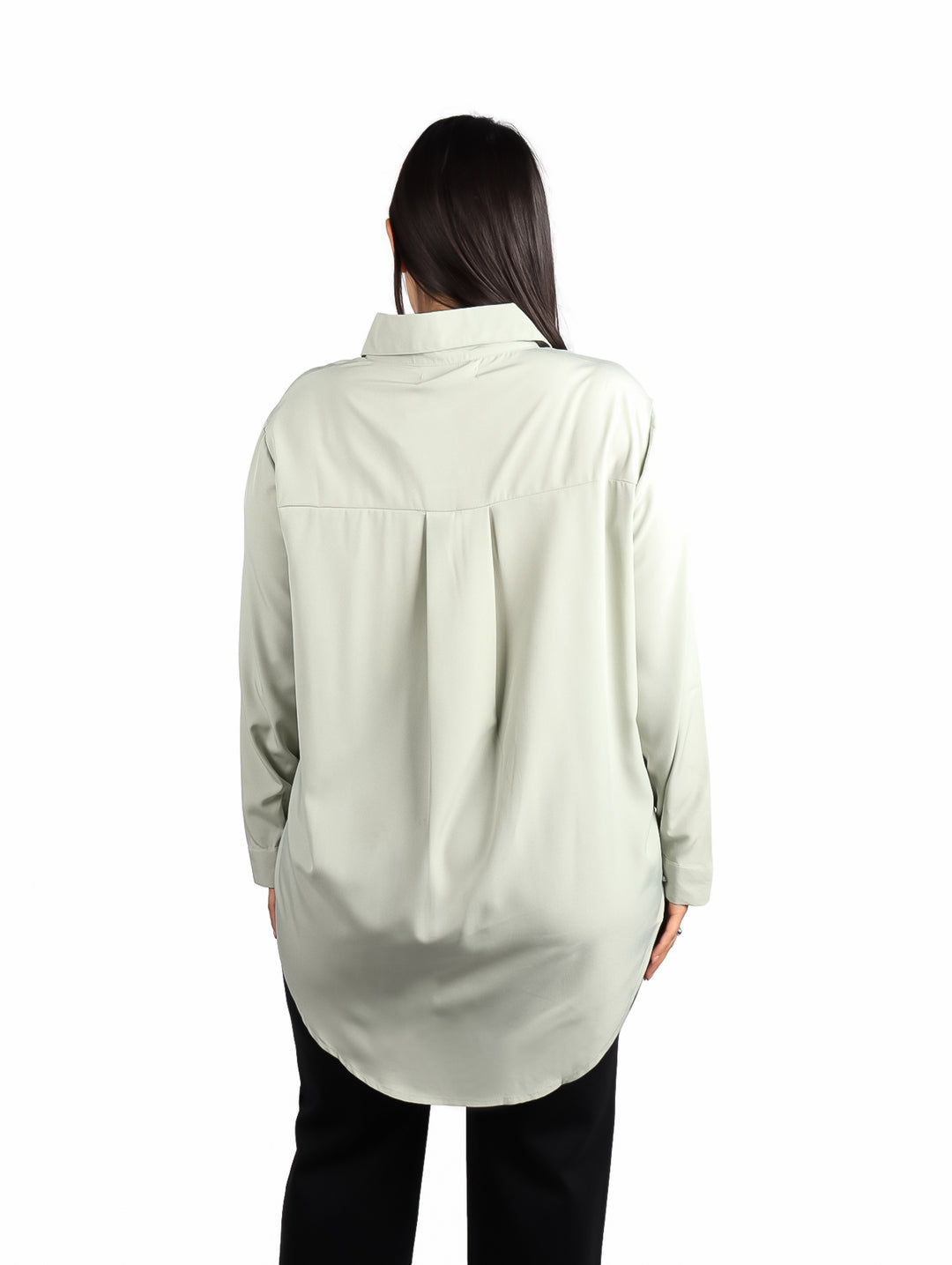 Mujer vistiendo camisa de color verde sage con manga larga y corte holgado.