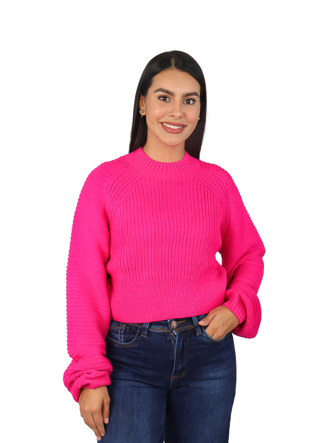 Mujer vistiendo un suéter rosa fucsia de manga bombacha y pantalones vaqueros azules.