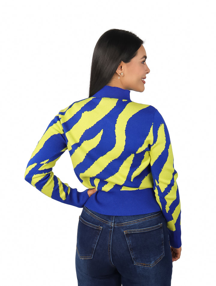 Mujer vistiendo suéter azul y verde lima con estampado animal print y cuello alto.