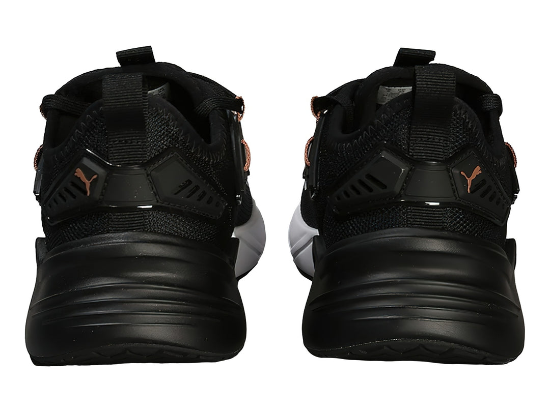 Tenis deportivos PUMA en color negro con suela blanca y detalles en oro rosa.