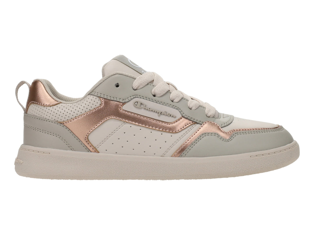 Tenis Champion color beige con detalles en oro rosa y suela blanca.