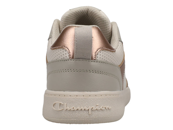 Tenis Champion color beige con detalles en oro rosa y suela blanca.