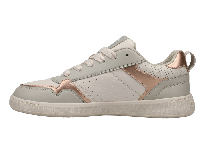 Tenis Champion color beige con detalles en oro rosa y suela blanca.
