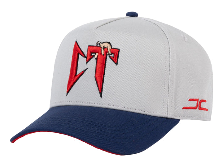 Gorra snapback gris con visera azul marino y detalles en rojo.