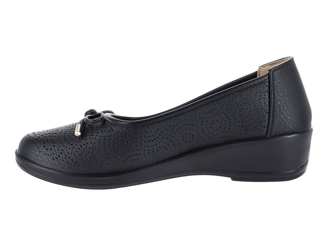 Zapato plano negro con textura perforada, detalle de moño dorado y suela ligera.