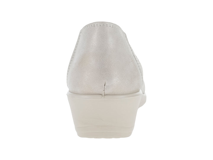 Zapato plano color beige con detalles perforados y un pequeño moño decorativo.