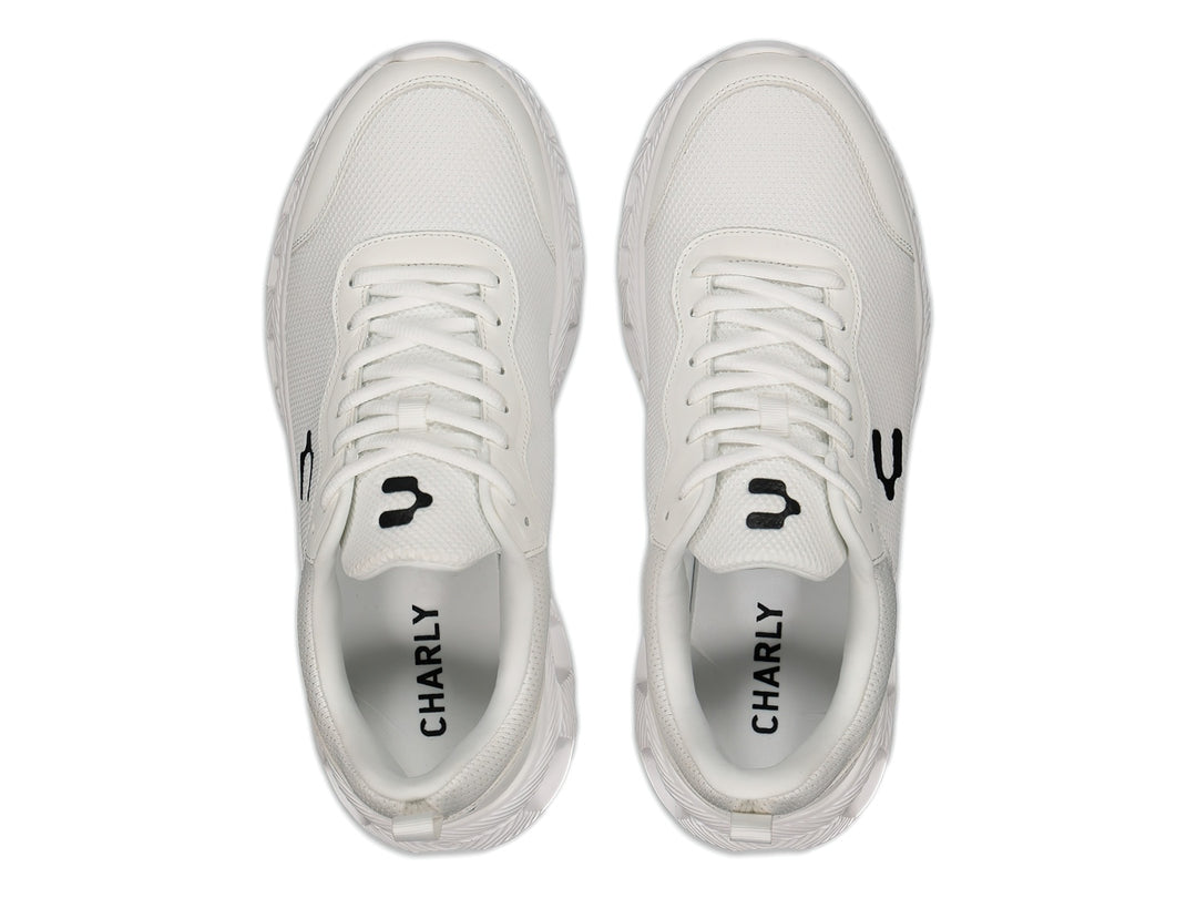 Tenis deportivos Charly de color blanco con logotipo negro en el costado y suela blanca.