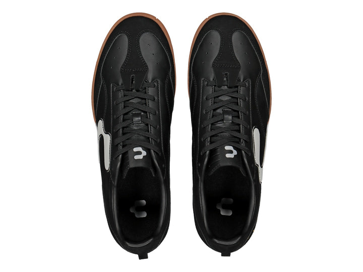 Zapato de fútbol Charly color negro con detalles blancos y suela de goma color café.