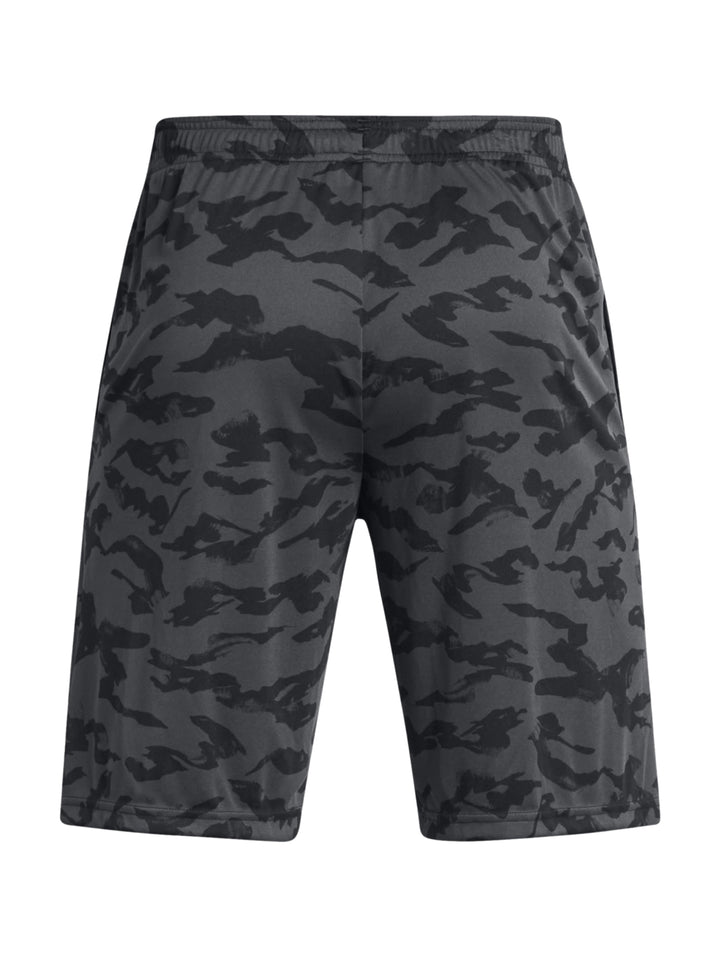 Hombre vistiendo shorts deportivos Under Armour con estampado de camuflaje en tonos negros y grises.