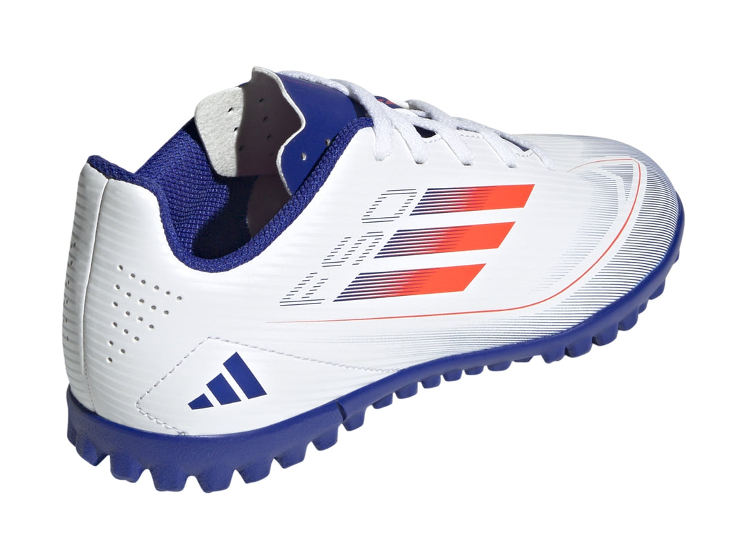 Zapato de fútbol Adidas F50 Club para niño, color blanco con suela azul y detalles en rojo.