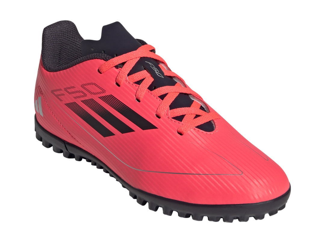 Tenis de fútbol Adidas F50 Club para niño en color rojo con detalles y suela en negro.