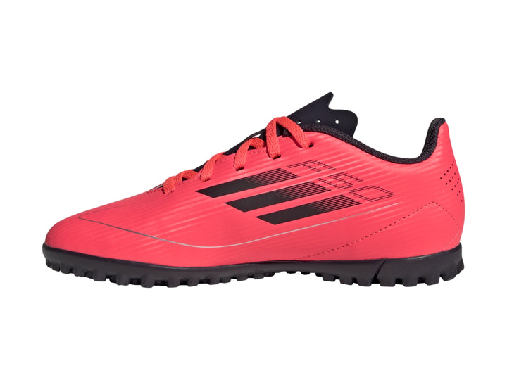 Tenis de fútbol Adidas F50 Club para niño en color rojo con detalles y suela en negro.