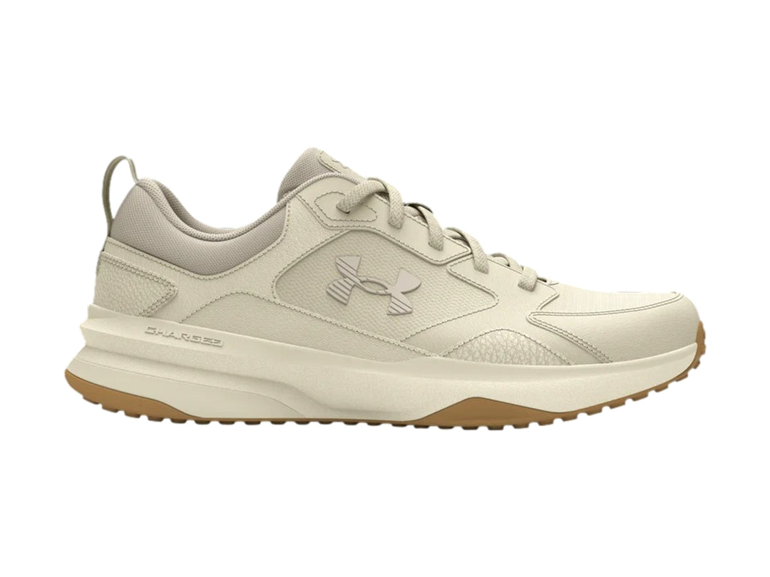Tenis deportivos Under Armour color blanco hueso con suela color marrón.