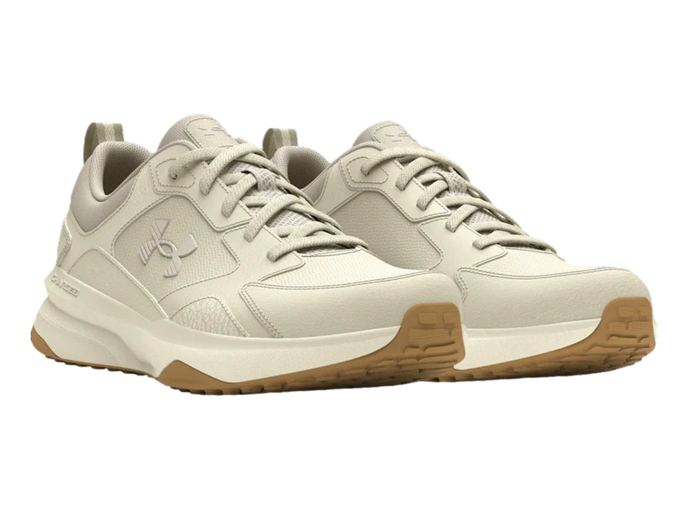 Tenis deportivos Under Armour color blanco hueso con suela color marrón.