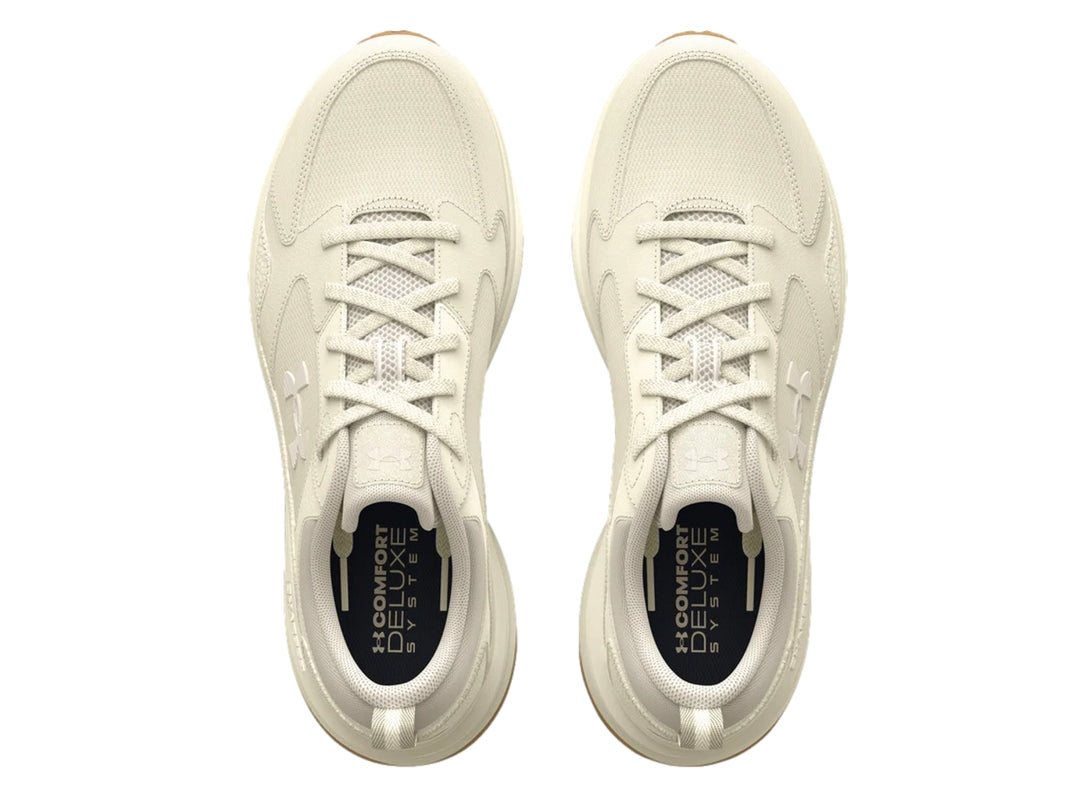 Tenis deportivos Under Armour color blanco hueso con suela color marrón.