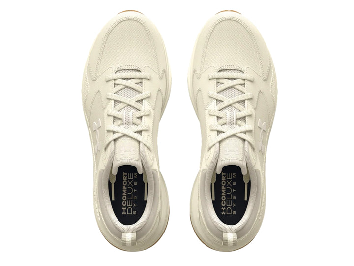 Tenis deportivos Under Armour color blanco hueso con suela color marrón.