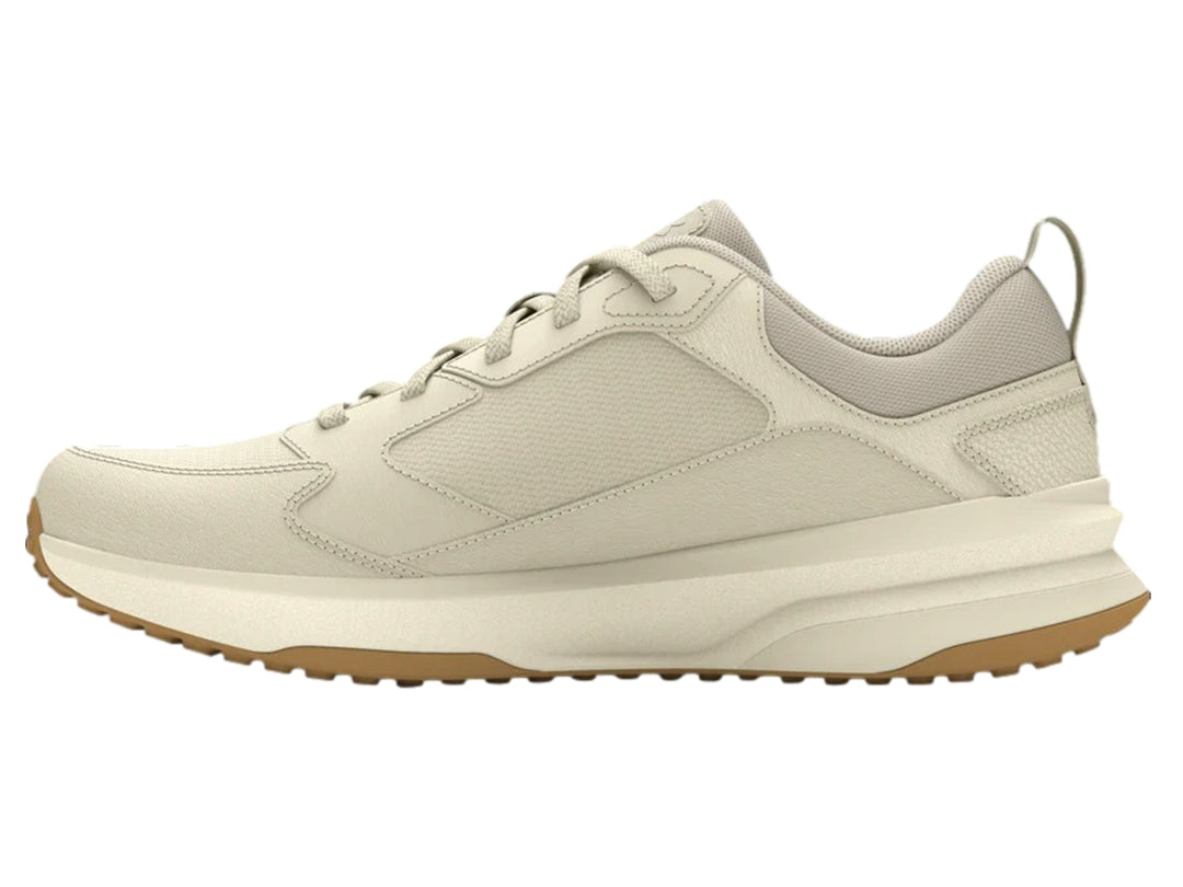Tenis deportivos Under Armour color blanco hueso con suela color marrón.