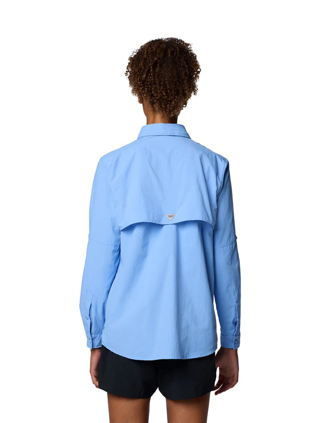 Mujer vistiendo camisa Columbia PFG Bahama II de manga larga en color azul claro con bolsillos frontales.