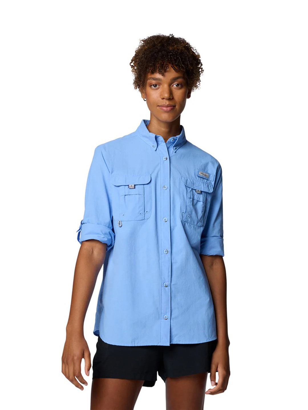 Mujer vistiendo camisa Columbia PFG Bahama II de manga larga en color azul claro con bolsillos frontales.