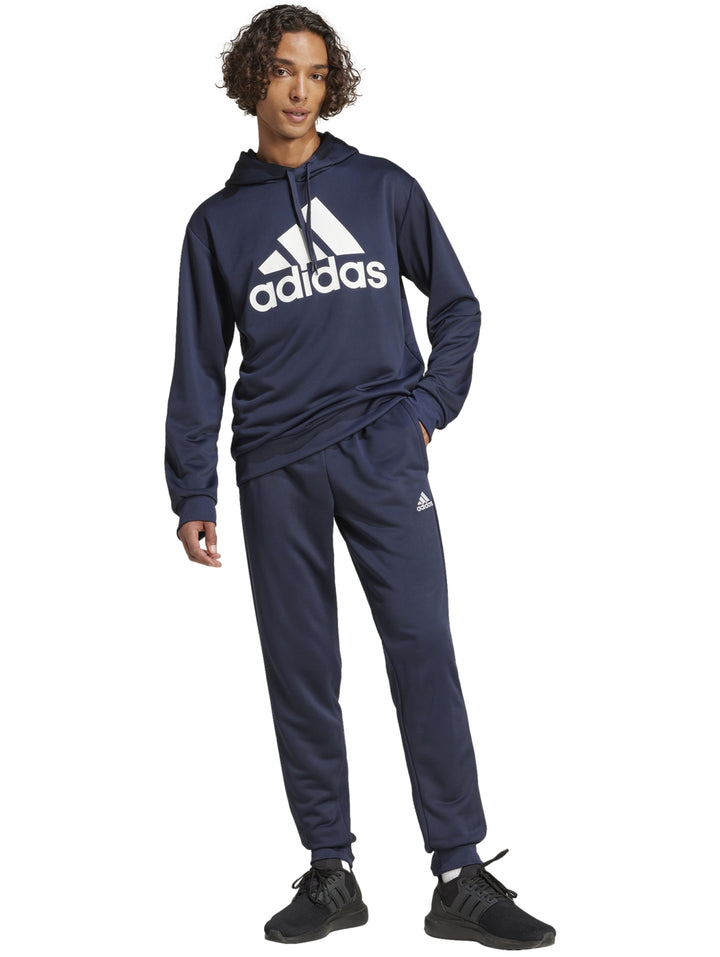 Hombre vistiendo un conjunto deportivo Adidas de color azul marino compuesto por sudadera con gorro y pantalón.