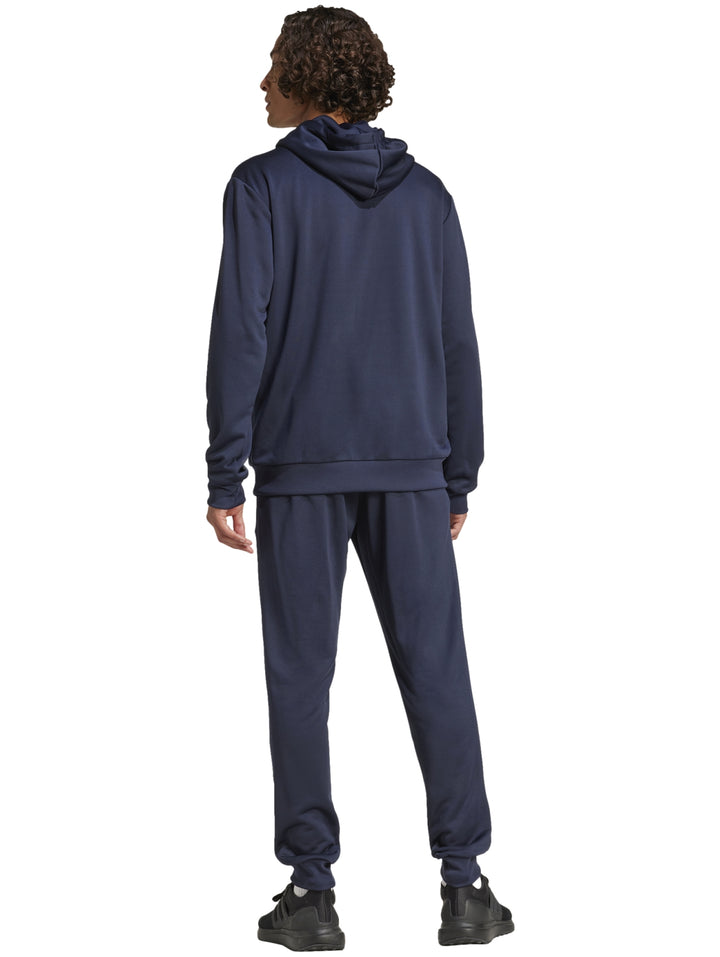 Hombre vistiendo un conjunto deportivo Adidas de color azul marino compuesto por sudadera con gorro y pantalón.
