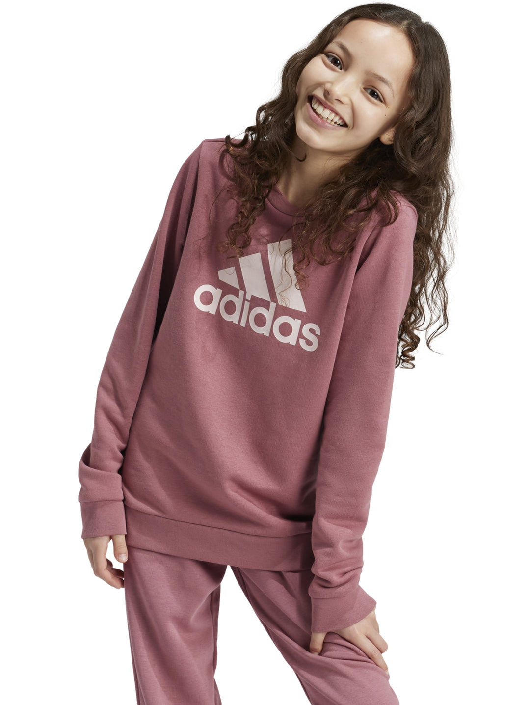 Niña vistiendo sudadera Adidas color Sand Strata con logotipo blanco grande en el pecho.