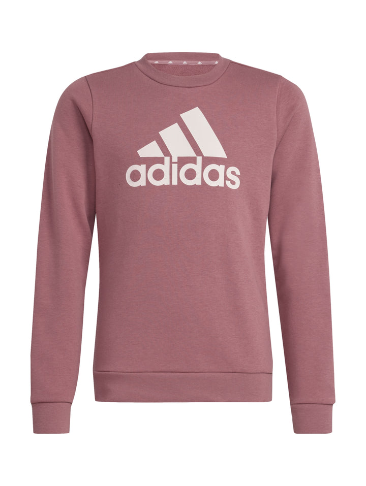 Niña vistiendo sudadera Adidas color Sand Strata con logotipo blanco grande en el pecho.