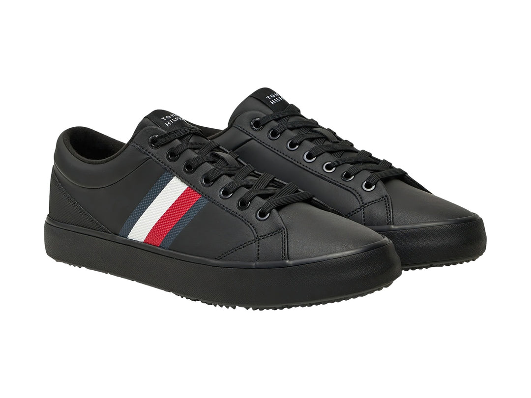 Tenis negros Tommy Hilfiger con franjas laterales en blanco, rojo y azul y suela negra.