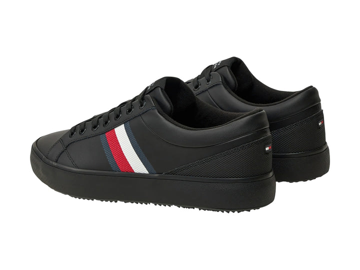 Tenis negros Tommy Hilfiger con franjas laterales en blanco, rojo y azul y suela negra.