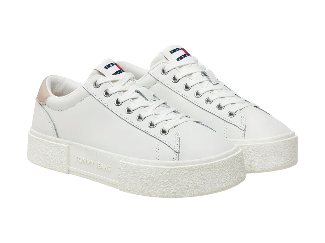 Tenis Tommy Hilfiger color ecru con detalle beige en el talón y suela de plataforma blanca.