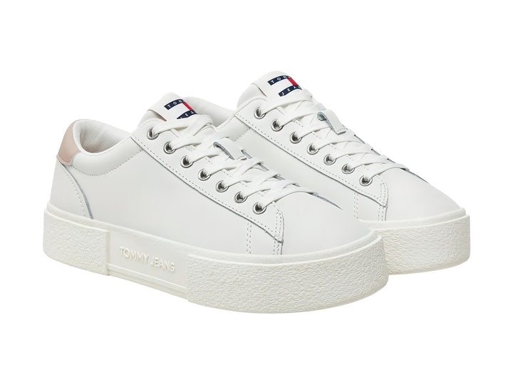 Tenis Tommy Hilfiger color ecru con detalle beige en el talón y suela de plataforma blanca.
