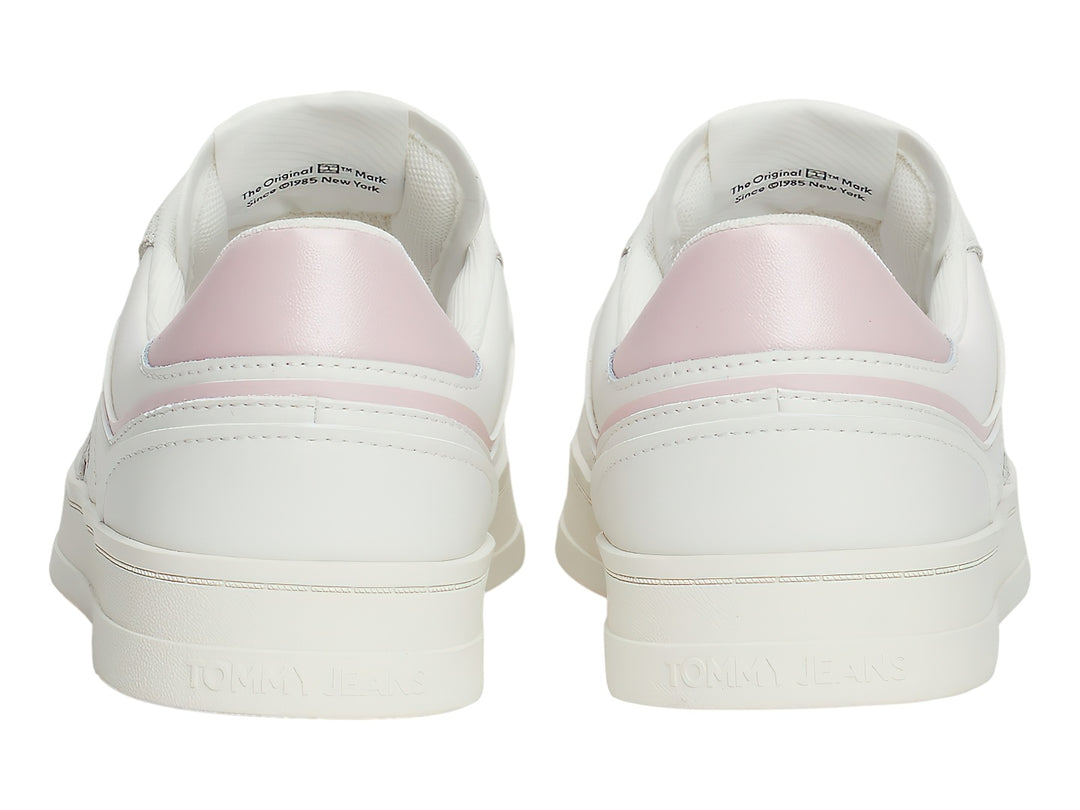 Tenis blancos Tommy Jeans con detalles en rosa pastel y suela blanca.