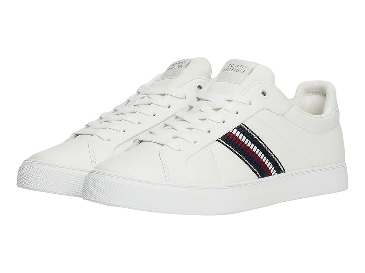 Tenis blancos Tommy Hilfiger con franja lateral tricolor en rojo, blanco y azul.