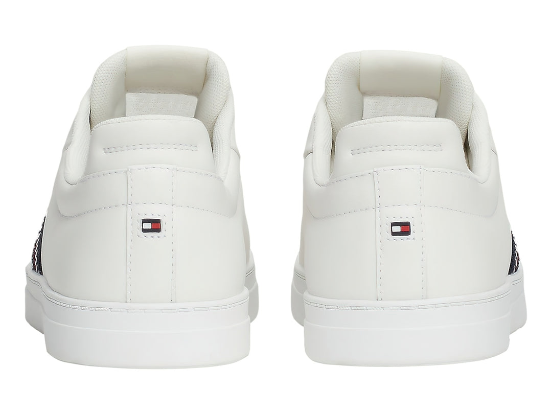 Tenis blancos Tommy Hilfiger con franja lateral tricolor en rojo, blanco y azul.
