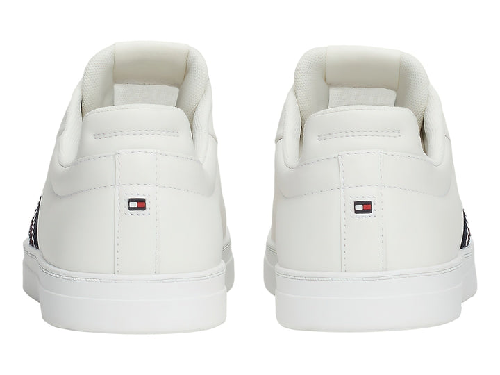Tenis blancos Tommy Hilfiger con franja lateral tricolor en rojo, blanco y azul.