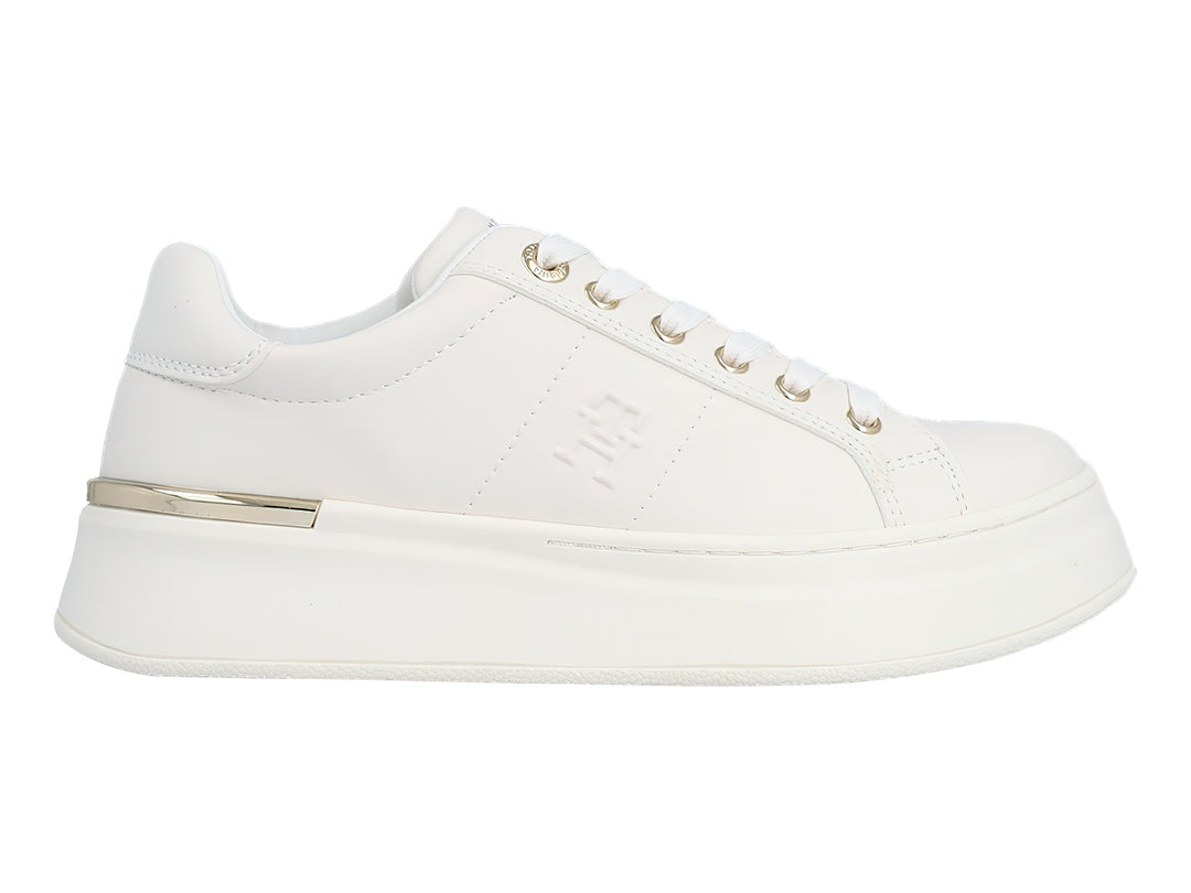 Tenis blancos de plataforma con cordones y detalles metálicos dorados en el talón y ojales.