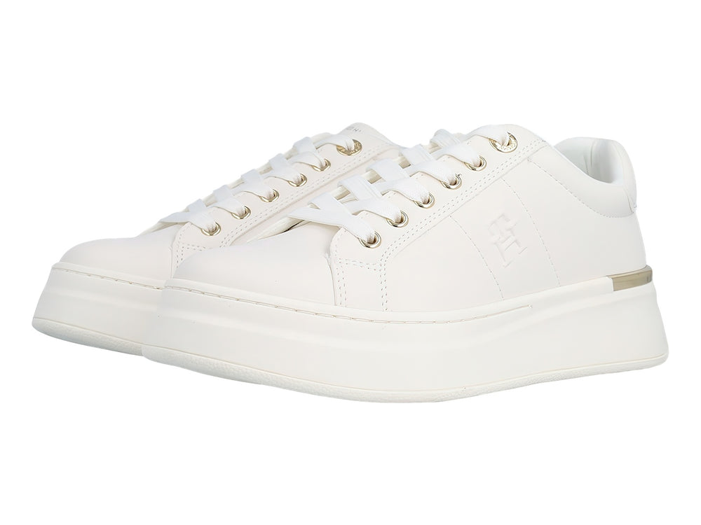 Tenis blancos de plataforma con cordones y detalles metálicos dorados en el talón y ojales.