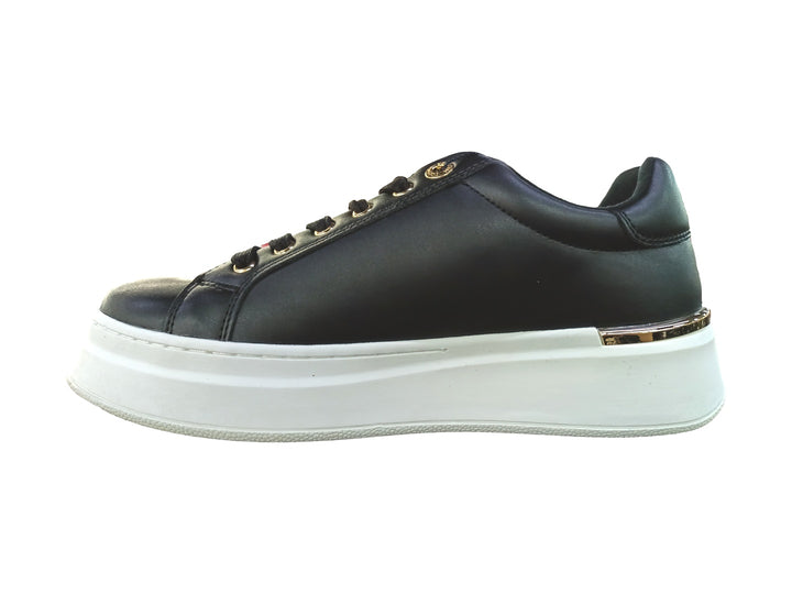 Tenis negros de corte bajo con suela blanca de plataforma y detalles dorados.